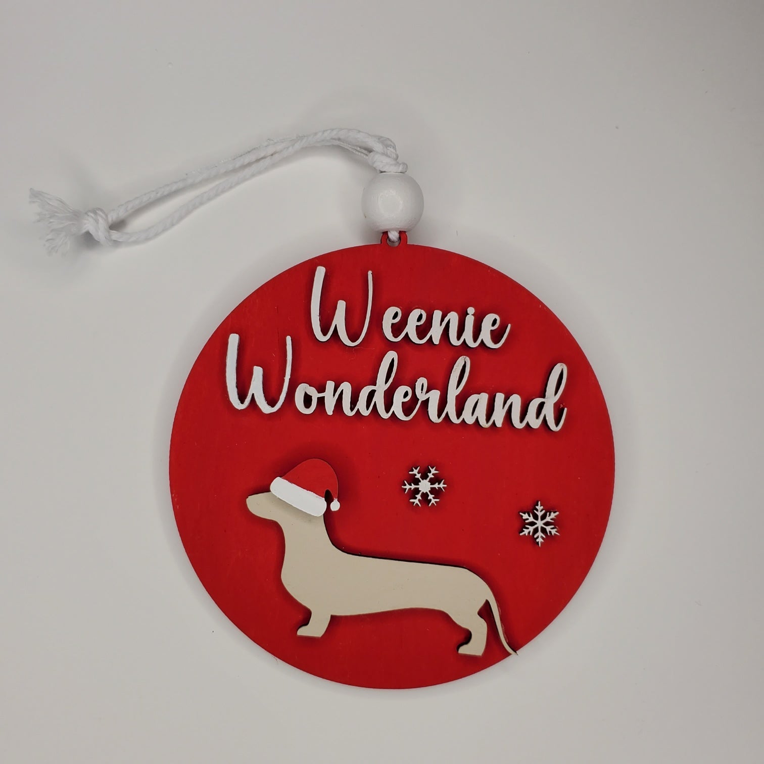 Red circular ornament with 'Weenie Wonderland' text and dachshund silhouette