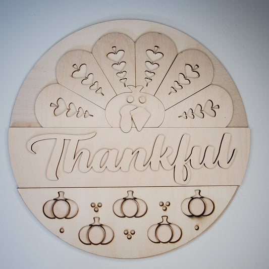 Wooden round decoration with 'Thankful' text and pumpkin designs
