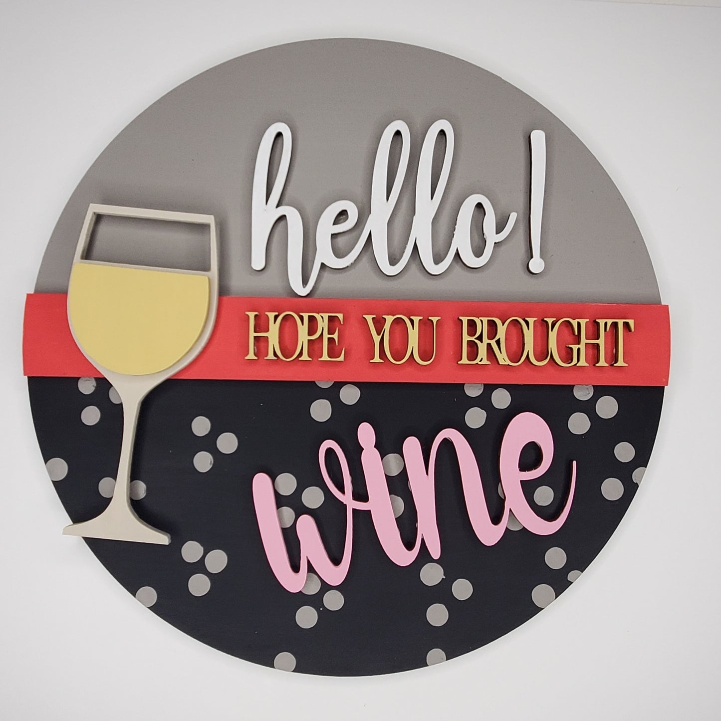 Decorative sign with a wine glass and text 'hello! Hope you brought wine' on a gray and black background. Door round or shelf leaner. Sizes 7inch, 12 inch or 16 inch. DIY kit available.