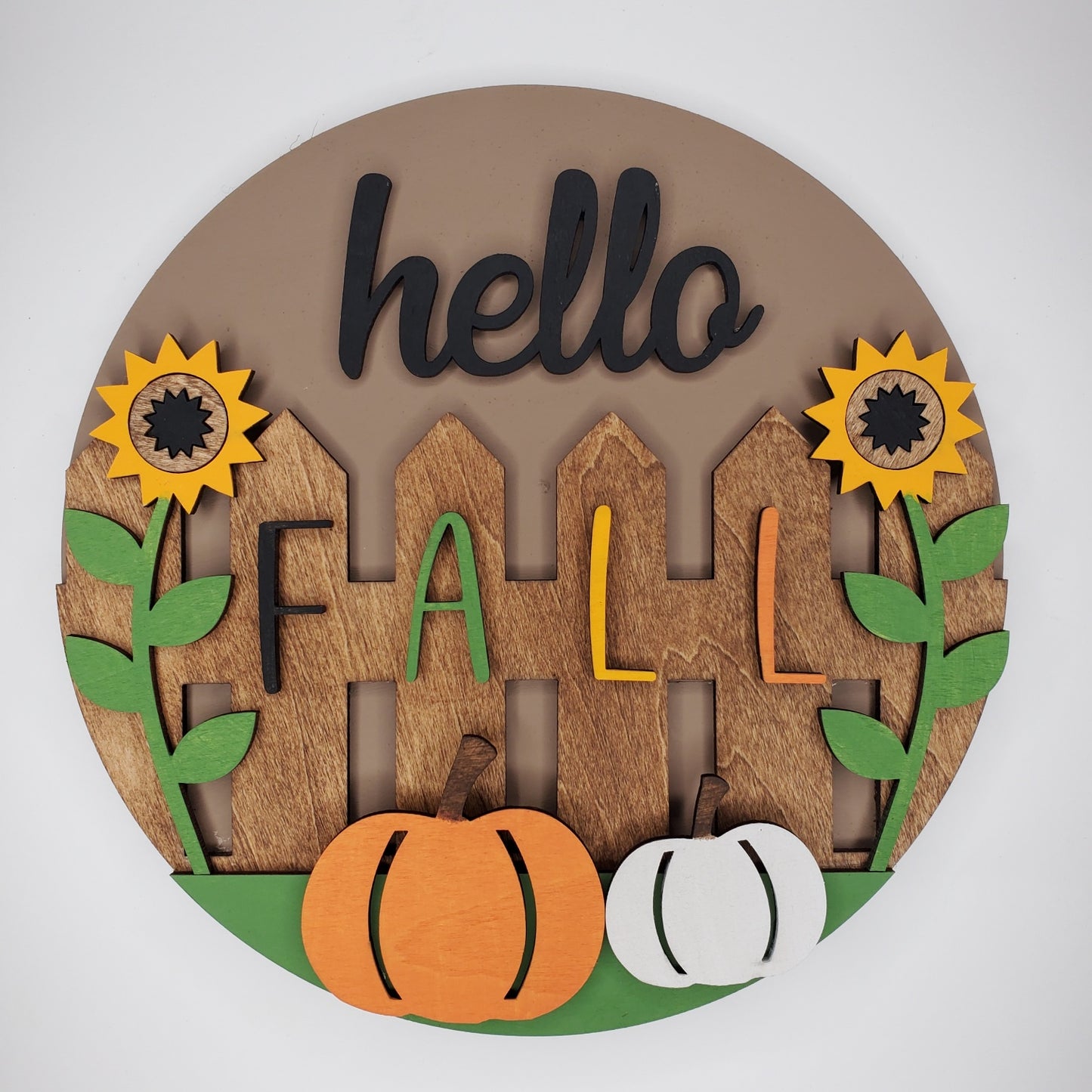 Decorative wall art with 'hello Fall' text and autumn elements on a door round. Easy to hang or display.