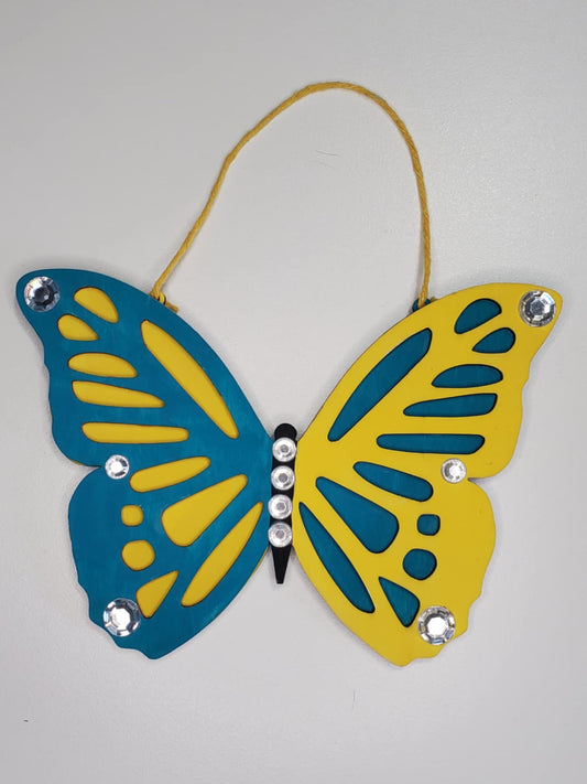 A Laser cut wood butterfly hand painted and adorned with rhinestones, ready to hang