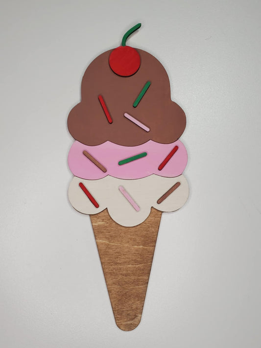 A laser cut wooden ice cream cone decoration, featuring a cone with 3 scoops of ice cream with sprinkles and a cherry on top.