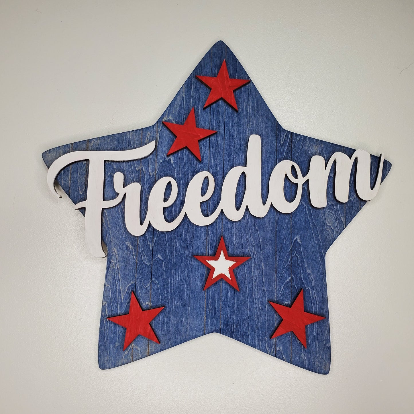 Star-shaped sign with 'Freedom' text and red stars on a white background
