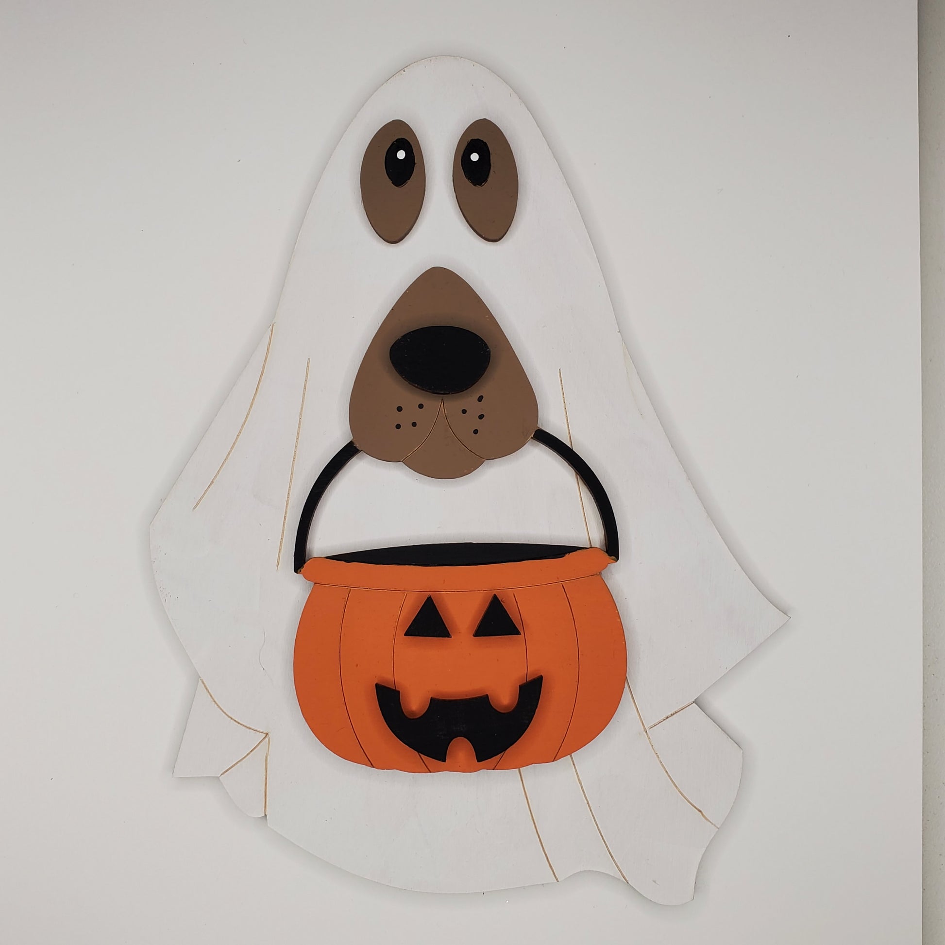 Halloween-themed wooden dog with ghost headpiece and jack-o'-lantern pumpkin bucket. DIY and finished piece available