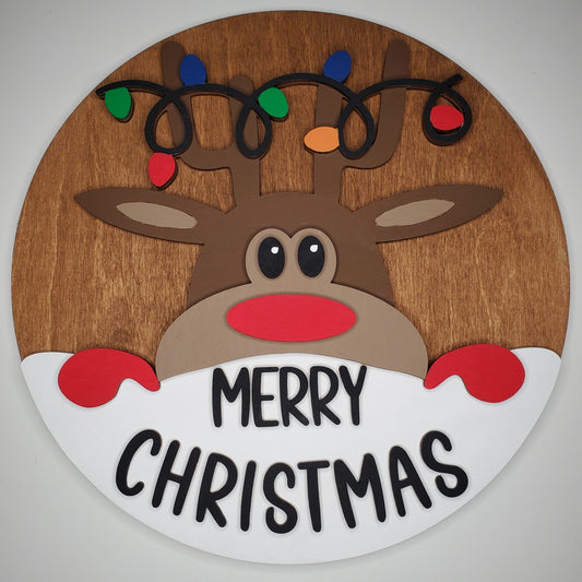 Wooden reindeer decoration with 'Merry Christmas' text and colorful lights on a plain background