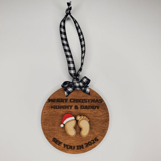 Wooden Christmas ornament with 'Merry Christmas Mommy & Daddy' text and baby feet design