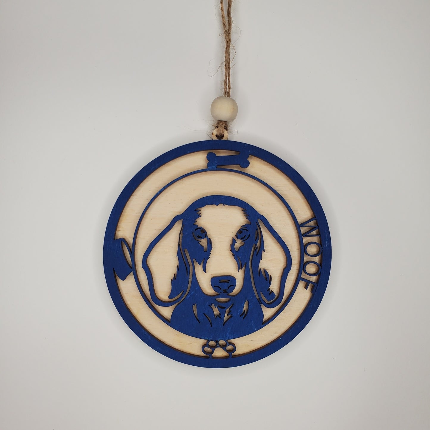 Decorative hanging ornament with a dog design and 'Woof' text on a plain background