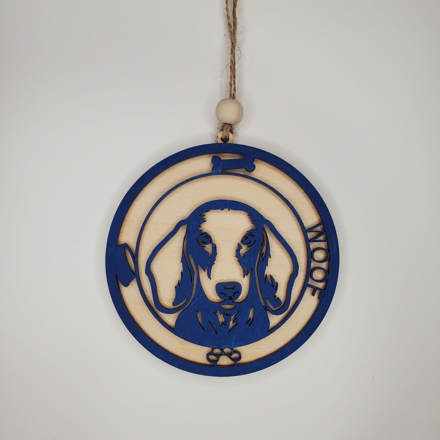 Decorative hanging ornament with a dog design and 'Woof' text on a plain background