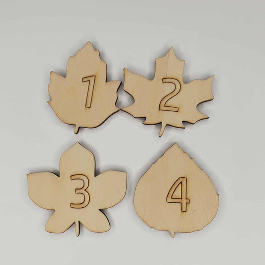 4 different shaped wooden numbered leaves with 1, 2, 3, 4 engraved onto the face